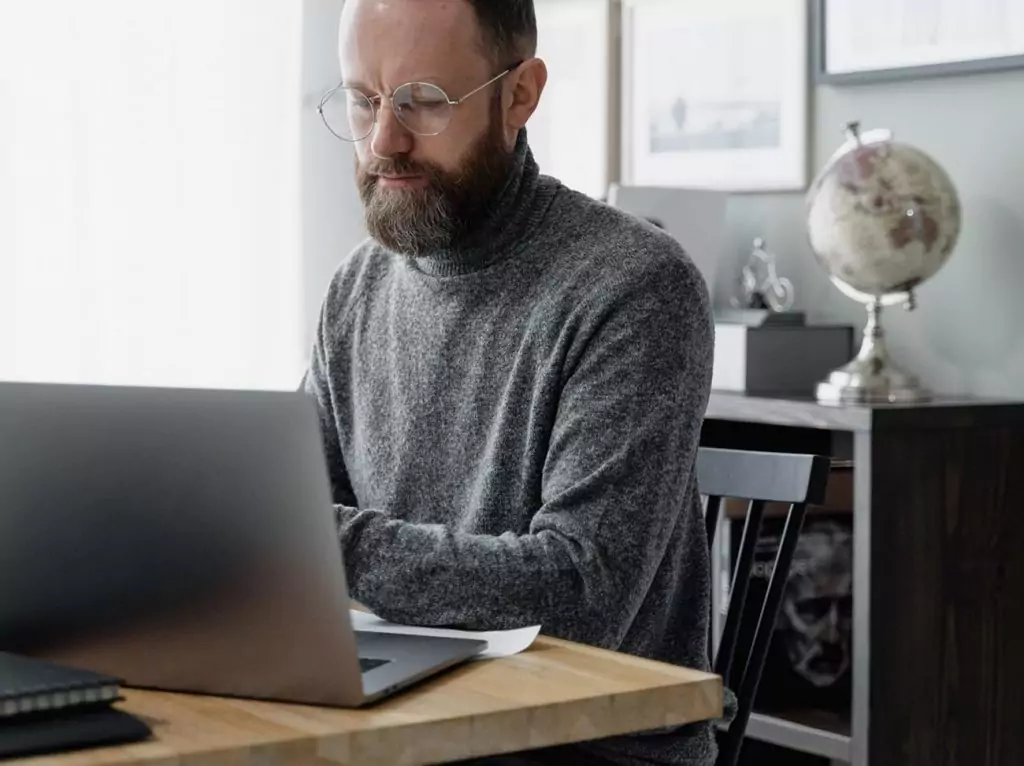 Person arbeitet am Laptop an Aufgaben der Immobilienverwaltung und Datenanalyse